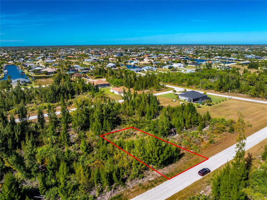 An aerial view shows a rectangular vacant lot outlined in red along a paved road — 9259 LINGLE STREET, PORT CHARLOTTE, FL