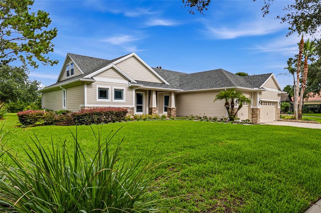 A tan, single-story suburban house with a gray shingled roof and a green lawn — 2208 PRINCESS JULIA LANE, LUTZ, FL
