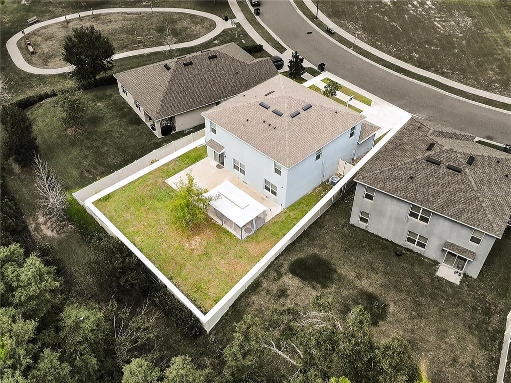 An aerial view shows a two-story house with a fenced backyard and a screened patio — 3759 CRIMSON CLOVER DRIVE, MOUNT DORA, FL