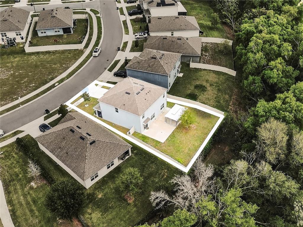 An aerial view shows a two-story house with a fenced backyard and a patio — 3759 CRIMSON CLOVER DRIVE, MOUNT DORA, FL