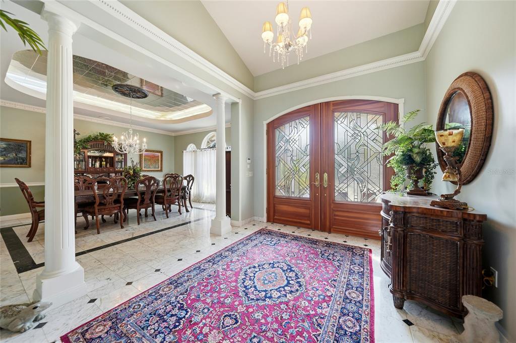 An entryway with a marble floor, a large pink rug, and double wooden doors — 24646 TANGERINE AVENUE, PORT CHARLOTTE, FL