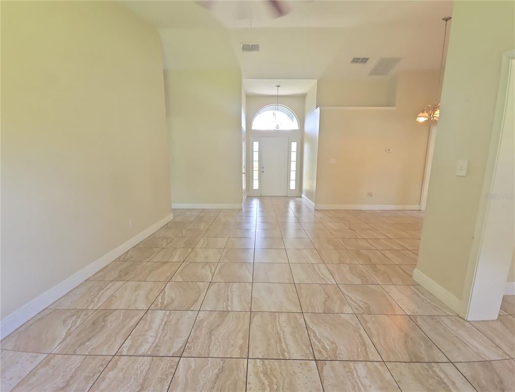 An interior view shows a tiled entryway with a high ceiling and a front door — 3820 BLACKBERRY CIRCLE UNIT St Cloud, ST CLOUD, FL