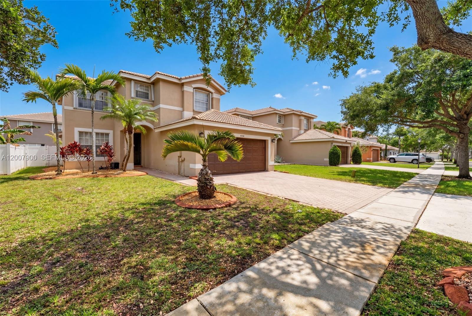 A two-story suburban house with a tan stucco exterior, a tile roof, and a driveway — 16438 SW 28th St, Miramar FL 33027, MIRAMAR, FL