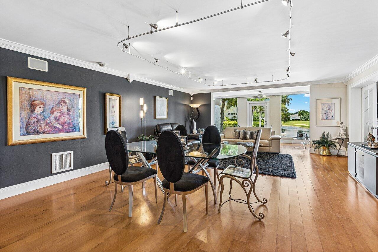 A dining area with a glass table and dark chairs opens to a living room — 7369 Orangewood Lane # 103, Boca Raton FL 33433, BOCA RATON, FL