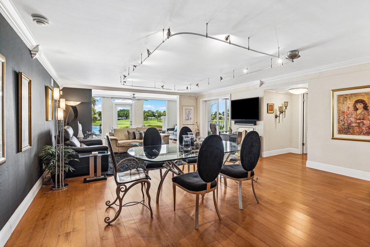 A dining area with a glass table and black chairs opens into a living room — 7369 Orangewood Lane # 103, Boca Raton FL 33433, BOCA RATON, FL