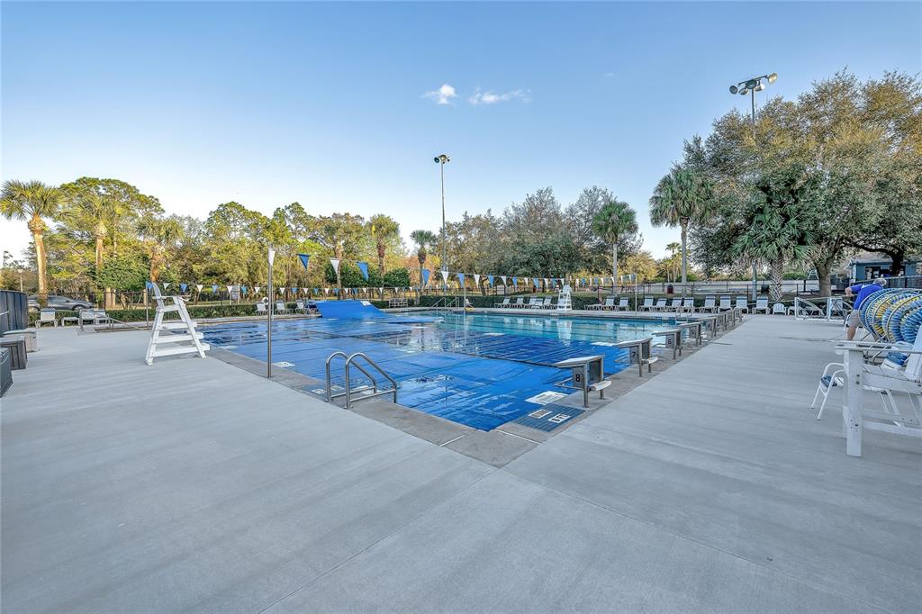 An outdoor swimming pool with a blue cover and starting blocks on a concrete deck — 2675 RUNNING SPRINGS LOOP, OVIEDO, FL