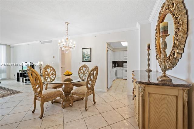 A dining area features a glass-topped table, four ornate chairs, and a chandelier — 2501 S Ocean Dr # 402, Hollywood FL 33019, HOLLYWOOD, FL