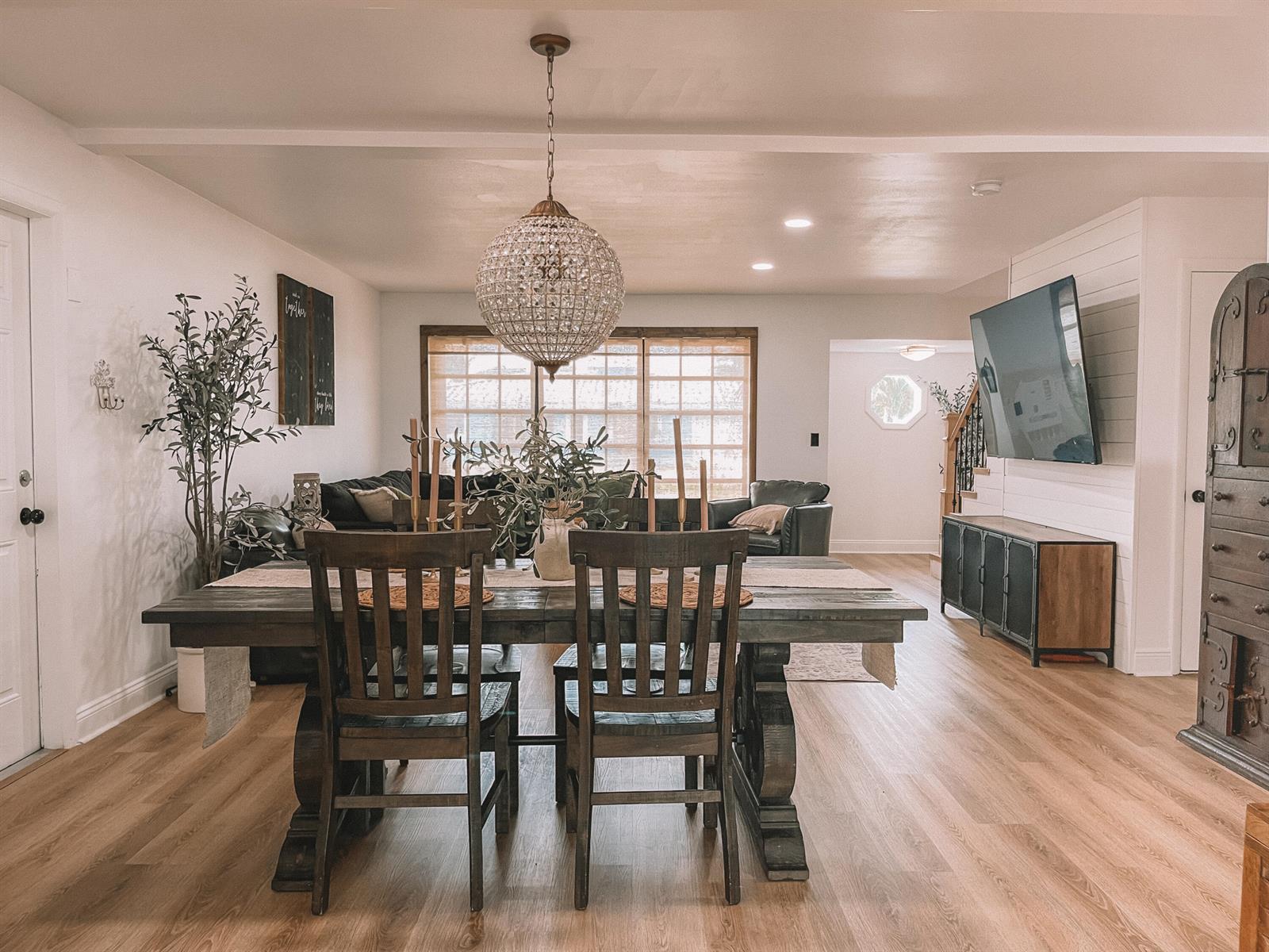 A dining area with a wooden table and crystal chandelier opens into a living room — 2171 NE 44th Court, Lighthouse Point FL 33064, LIGHTHOUSE POINT, FL