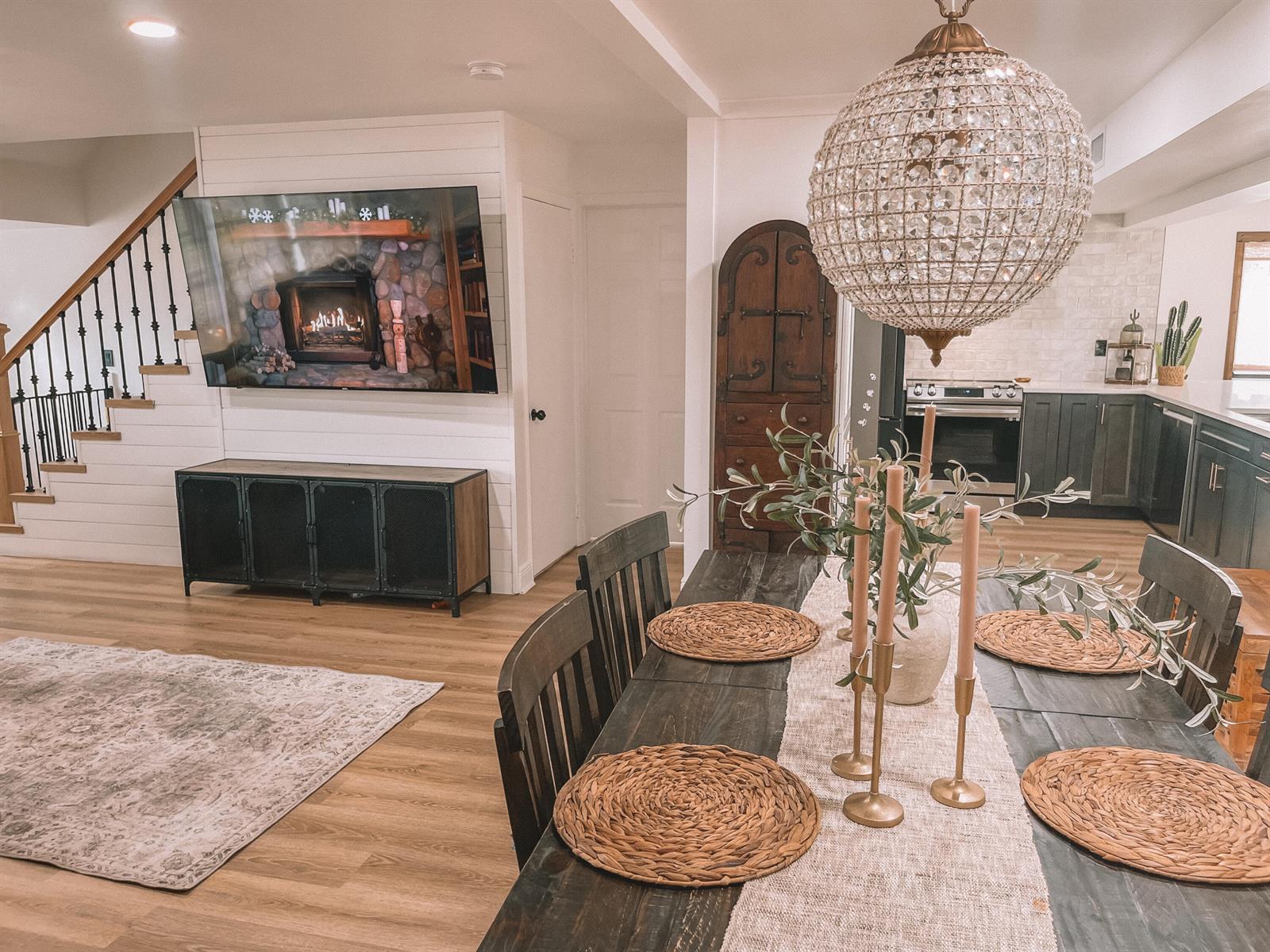 A dining area with a crystal chandelier overlooks a living room featuring a wall-mounted television — 2171 NE 44th Court, Lighthouse Point FL 33064, LIGHTHOUSE POINT, FL
