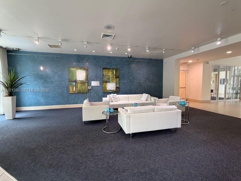 A modern lobby features white sofas, blue accent walls, and two abstract paintings — 2000 N Bayshore Dr # 126, Miami FL 33137, MIAMI, FL