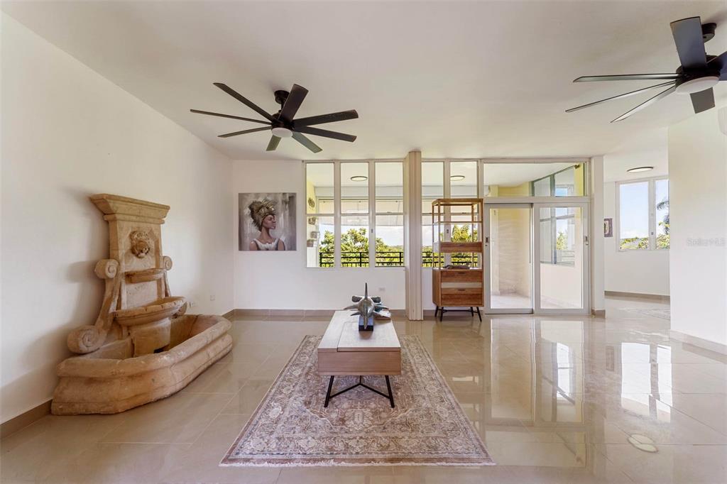 A kitchen with white upper cabinets, wood-tone lower cabinets, stainless steel appliances, and exposed brick — 3104 EL DORADO CLUB UNIT 3104, VEGA ALTA, PR