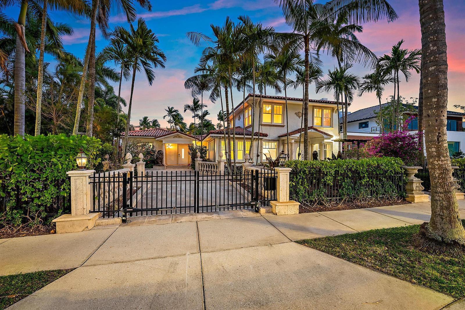 A two-story house with a gated driveway, palm trees, and a tile roof at dusk — 228 9th Street, West Palm Beach FL 33401, WEST PALM BEACH, FL