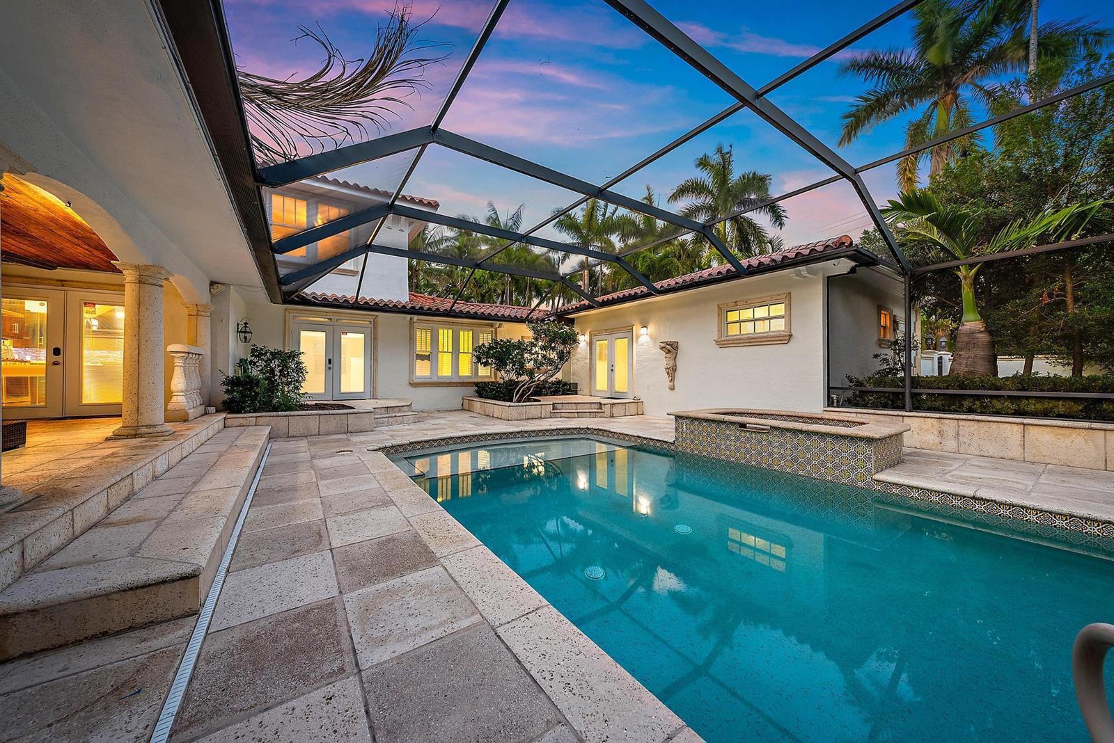 A screened-in patio features a swimming pool, a hot tub, and stone tile flooring — 228 9th Street, West Palm Beach FL 33401, WEST PALM BEACH, FL