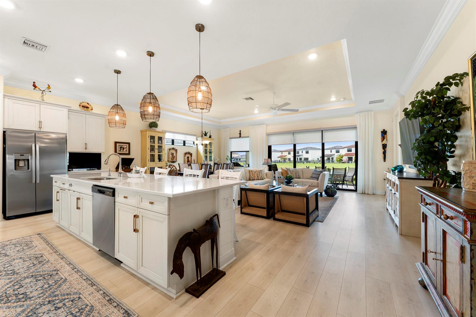 A bright, open-concept kitchen and living area with white cabinetry, a large island, and tile flooring — 16148 Key Biscayne Lane, Westlake FL 33470, WESTLAKE, FL