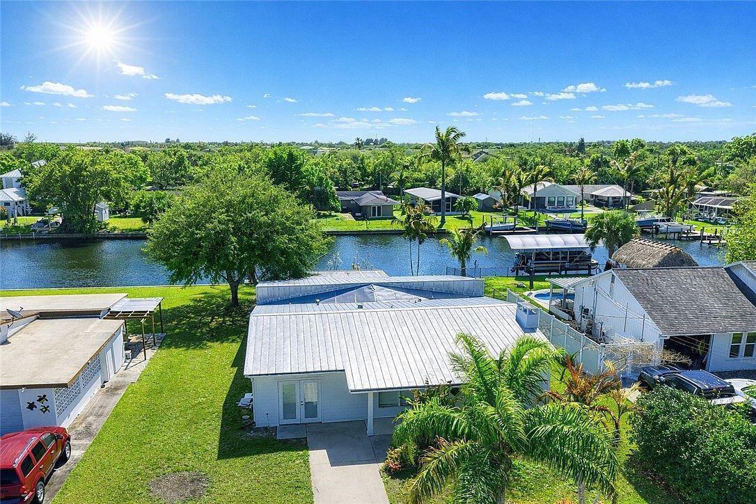 A white house with a concrete walkway and a palm tree in the front yard — 241 14th Place, Vero Beach FL 32960, VERO BEACH, FL