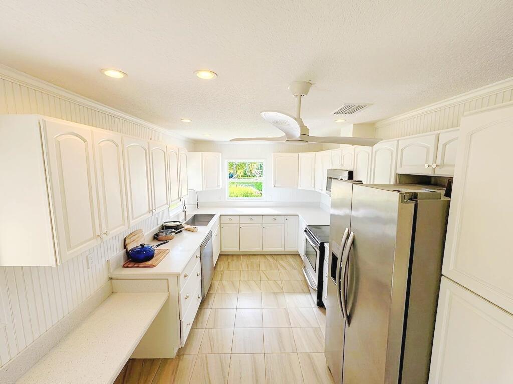 An aerial view of a white house with a metal roof next to a canal — 241 14th Place, Vero Beach FL 32960, VERO BEACH, FL