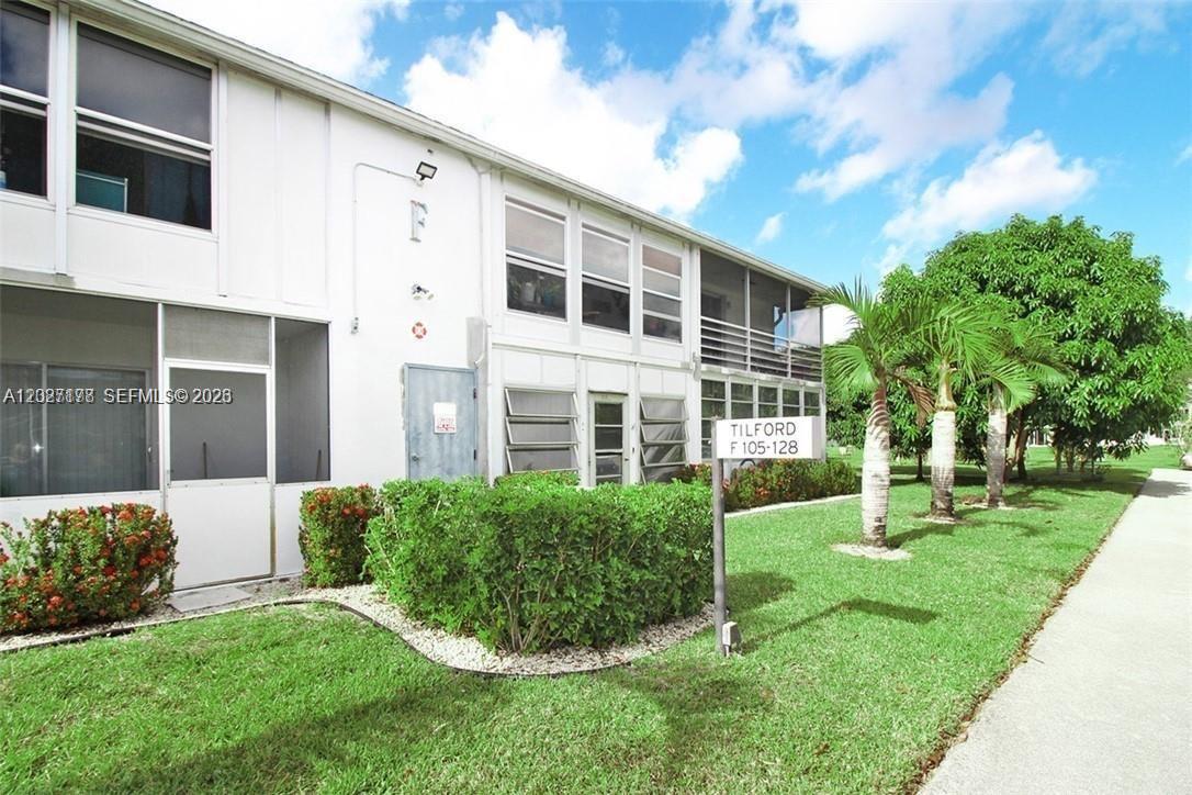 A two-story residential building features white siding, screened-in patios, and a sign labeled Tilford — 111 Tilford F # 111, Deerfield Beach FL 33442, DEERFIELD BEACH, FL