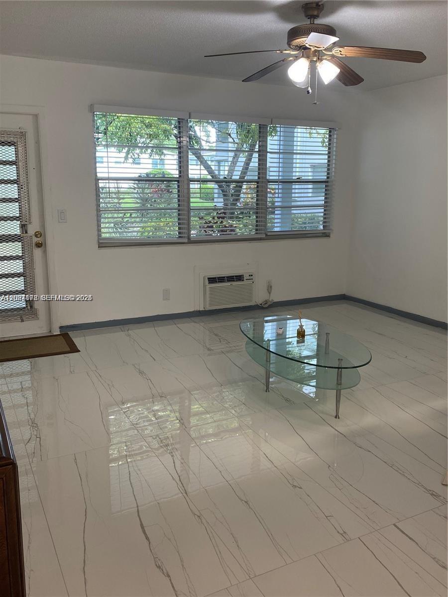 A living room features white marble-look tile floors, a ceiling fan, and a glass coffee table — 111 Tilford F # 111, Deerfield Beach FL 33442, DEERFIELD BEACH, FL