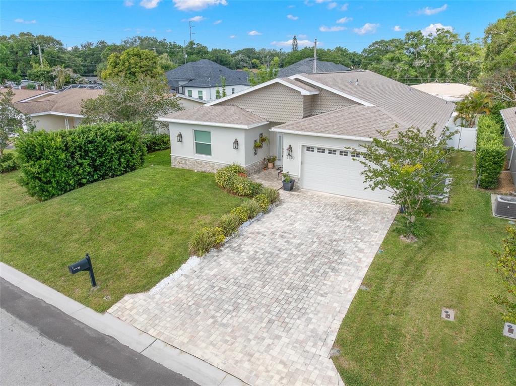 An elevated exterior view of a single-story house with a paved driveway and green lawn — 1720 VERDE DRIVE, CLEARWATER, FL
