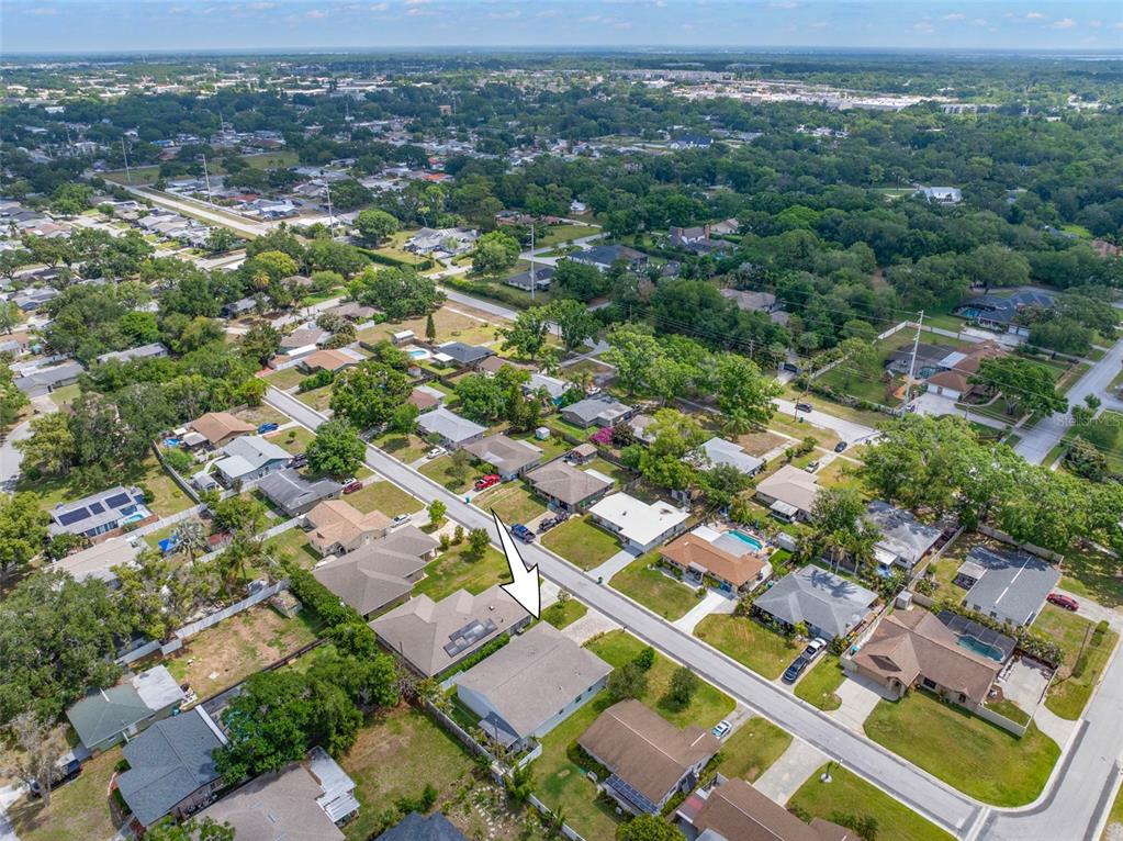 An aerial view shows a residential neighborhood with single-family homes, green trees, and paved streets — 1720 VERDE DRIVE, CLEARWATER, FL
