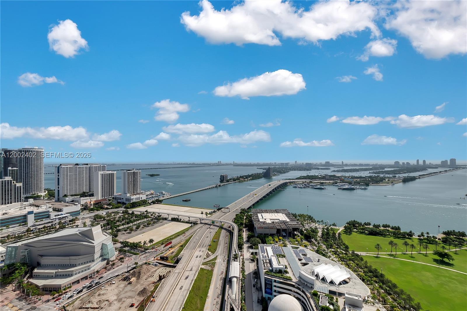 An aerial view shows a highway bridge crossing a bay near a city skyline — 1100 Biscayne Blvd # 3901, Miami FL 33132, MIAMI, FL