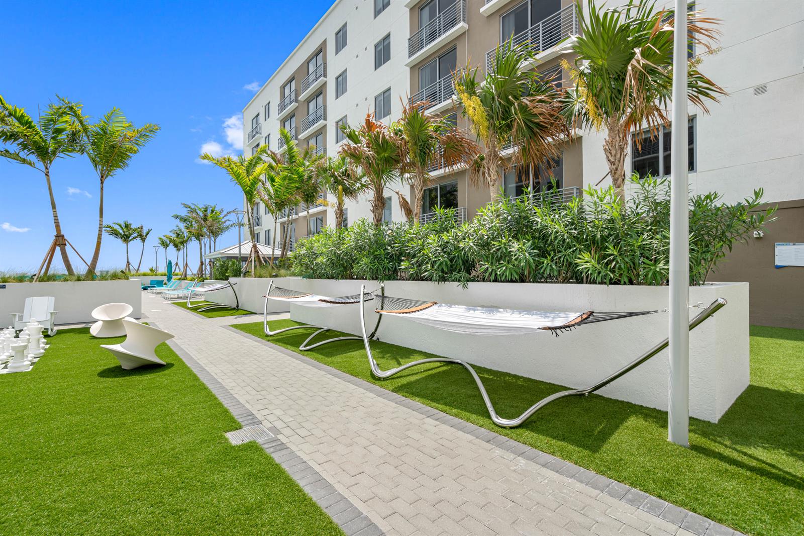 An outdoor courtyard features hammocks, modern chairs, a giant chess set, and palm trees — 200 NE 1st Avenue # 633, Pompano Beach FL 33060, POMPANO BEACH, FL