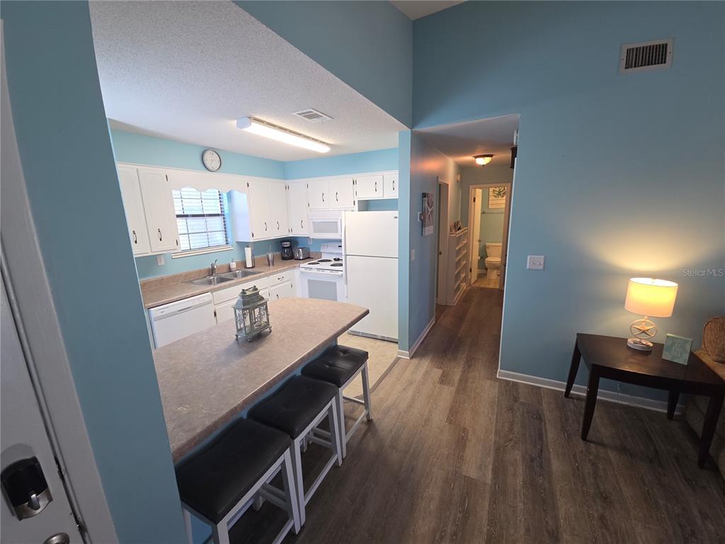 A kitchen with white cabinets, a breakfast bar, and light blue walls — 644 16TH STREET, PANAMA CITY BEACH, FL