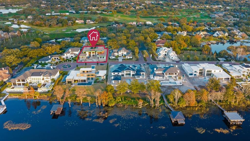 An aerial view shows a residential neighborhood with a highlighted house under construction near water — 7011 VIA CARMEL WAY, ORLANDO, FL