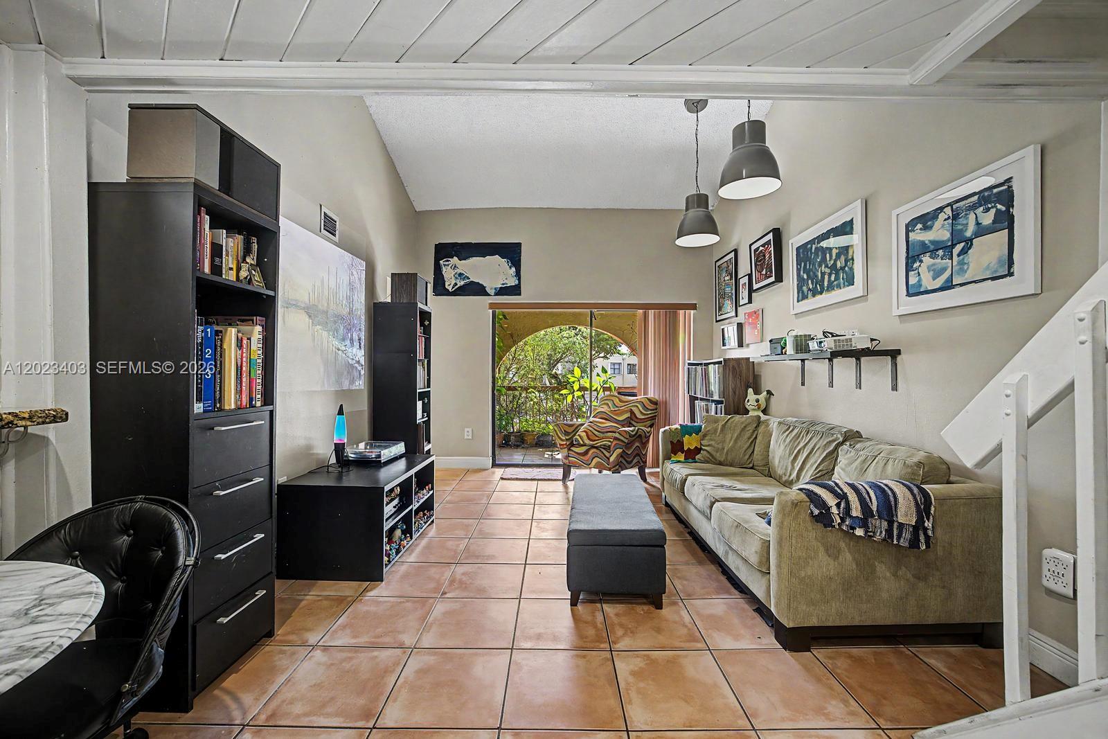A living room features tile floors, a sofa, a bookshelf, and a sliding glass door — 10233 NW 9th St Cir # 1, Miami FL 33172, MIAMI, FL