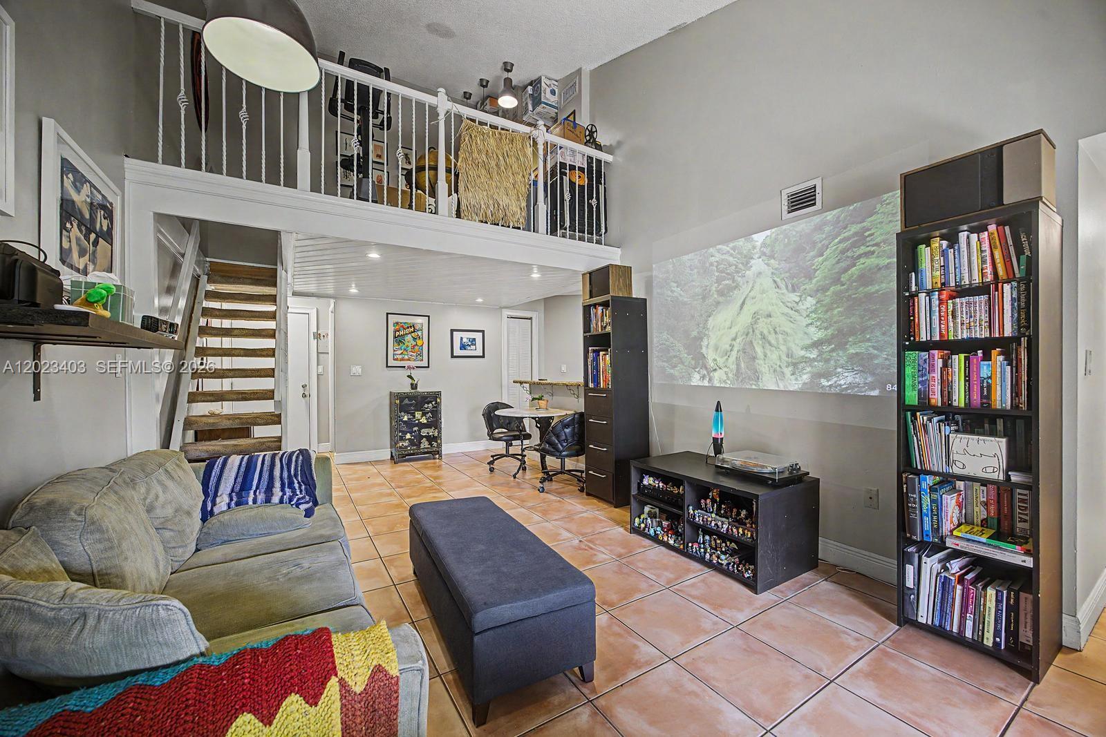 A living room features a projector screen, a lofted area, and a tall bookshelf — 10233 NW 9th St Cir # 1, Miami FL 33172, MIAMI, FL