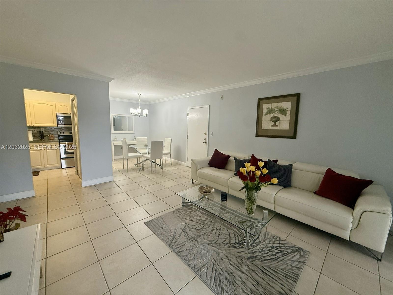 A living room and dining area feature light-colored tile floors and a white sofa — 10413 N Kendall Dr # B208, Miami FL 33176, MIAMI, FL