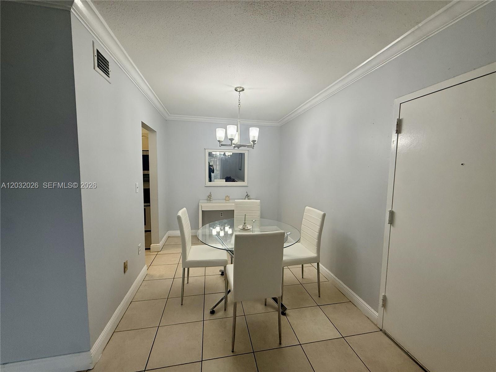 A dining area features a glass table, four white chairs, and a light fixture — 10413 N Kendall Dr # B208, Miami FL 33176, MIAMI, FL