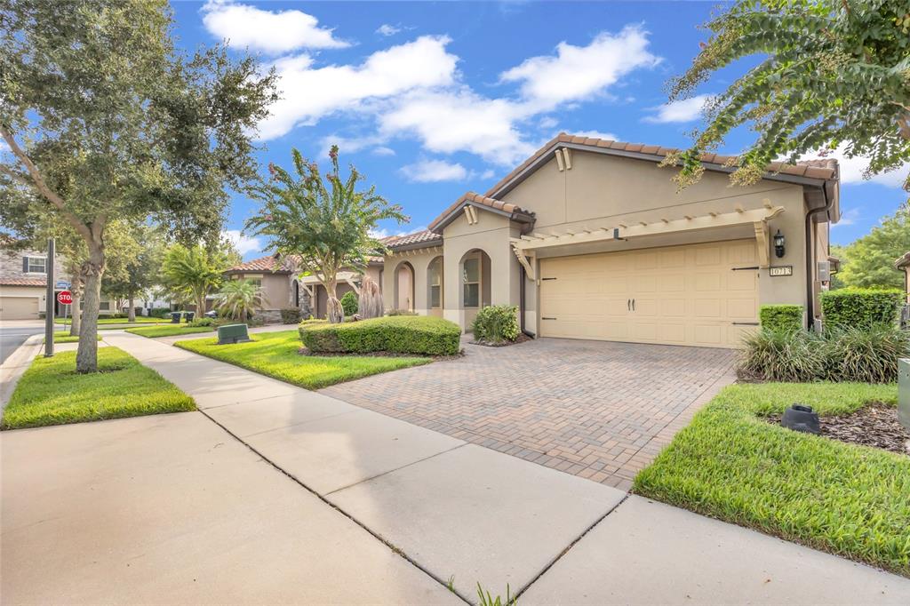 A single-story house with a beige stucco exterior, a two-car garage, and a paved driveway — 10713 BERRY CREEK ROAD, ORLANDO, FL