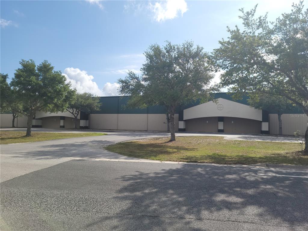 A long, single-story industrial building with metal siding stands behind a paved parking lot — 1501 SW 44TH AVENUE, OCALA, FL