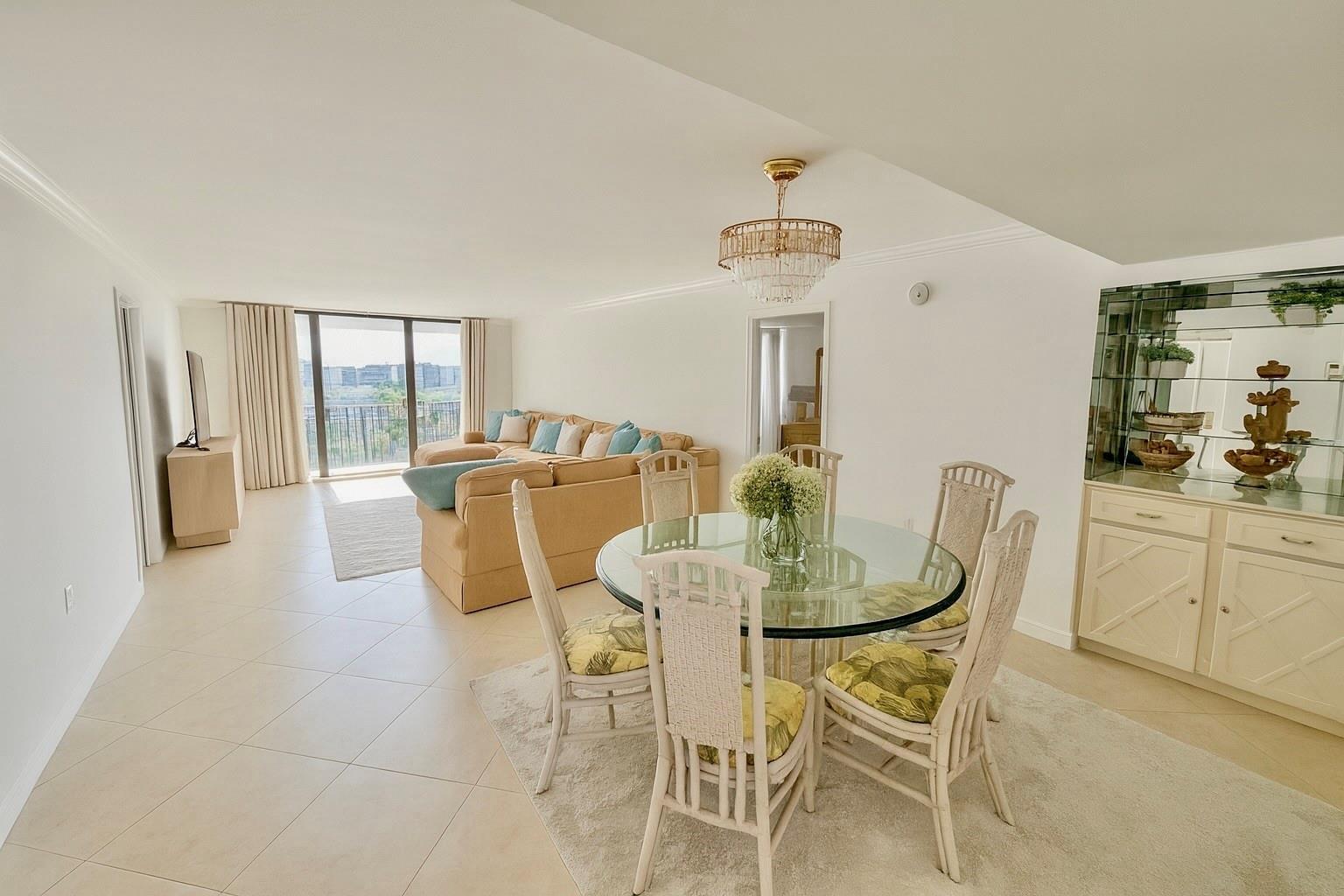 A dining area with a glass table and chairs sits before a living room with balcony views — 3460 S Ocean Boulevard # 608, Palm Beach FL 33480, PALM BEACH, FL