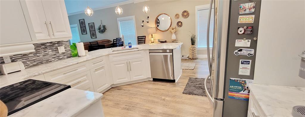 A paved patio with a small table and two chairs overlooks a lush, wooded backyard — 5330 RIVERWALK PRESERVE DRIVE, NEW PORT RICHEY, FL