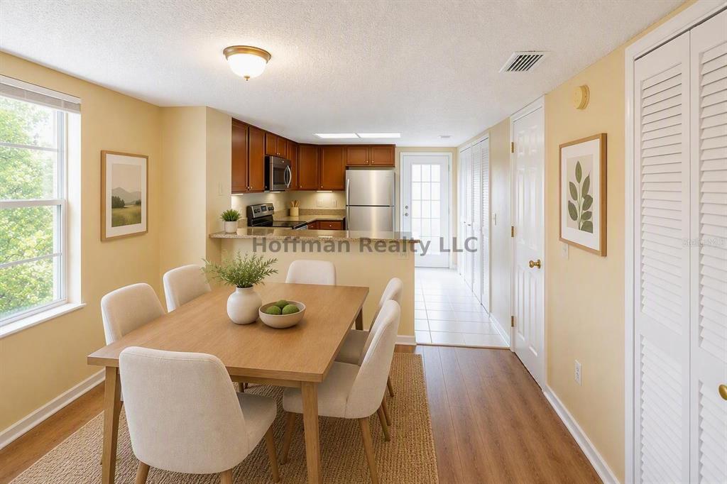 A dining area with a wooden table and chairs sits adjacent to an open kitchen — 2263 FLETCHERS POINT CIRCLE, TAMPA, FL