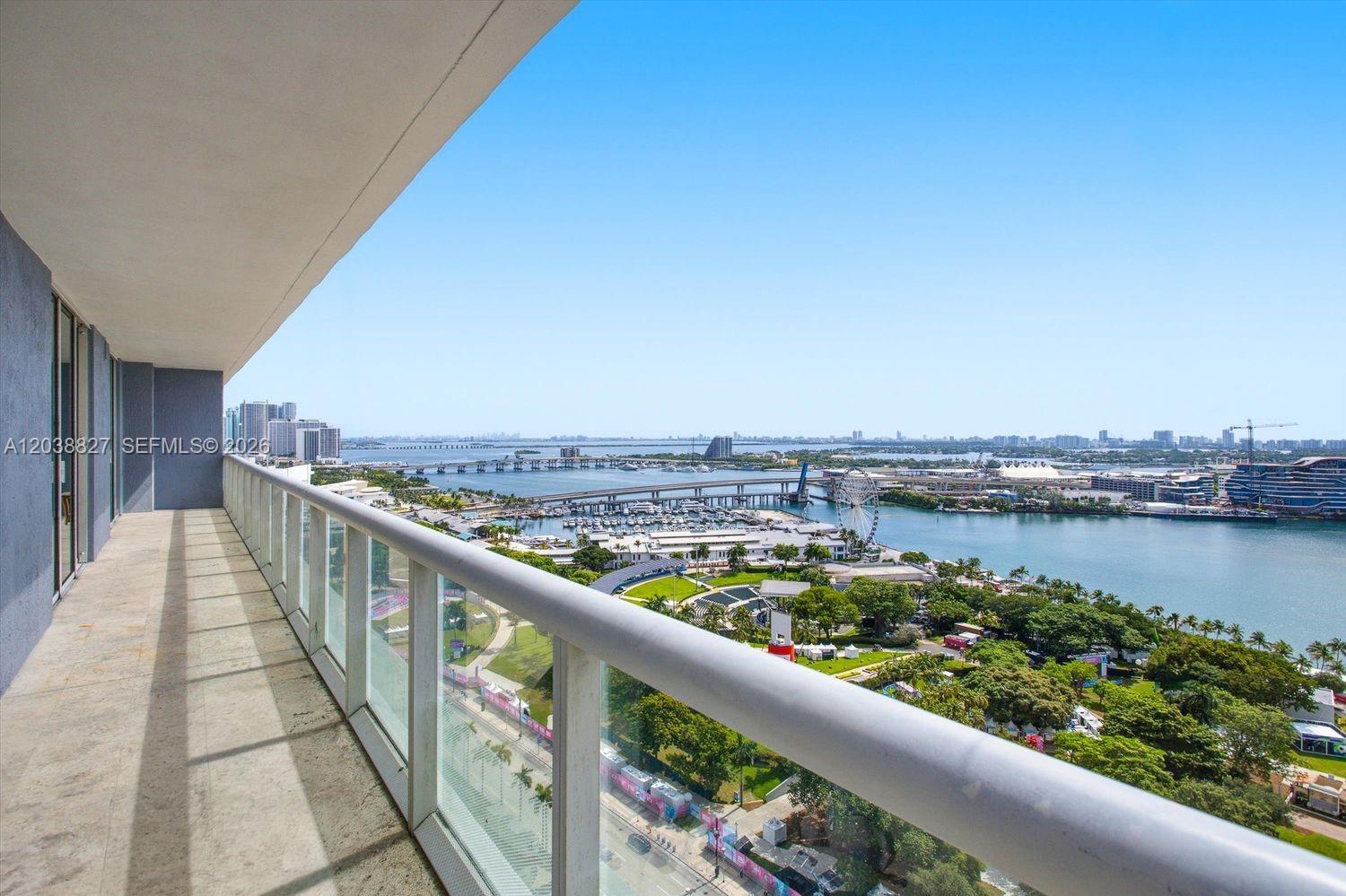 A high-rise balcony overlooks a park, a marina, and a bridge over the water — 50 Biscayne Blvd # 2510, Miami FL 33132, MIAMI, FL