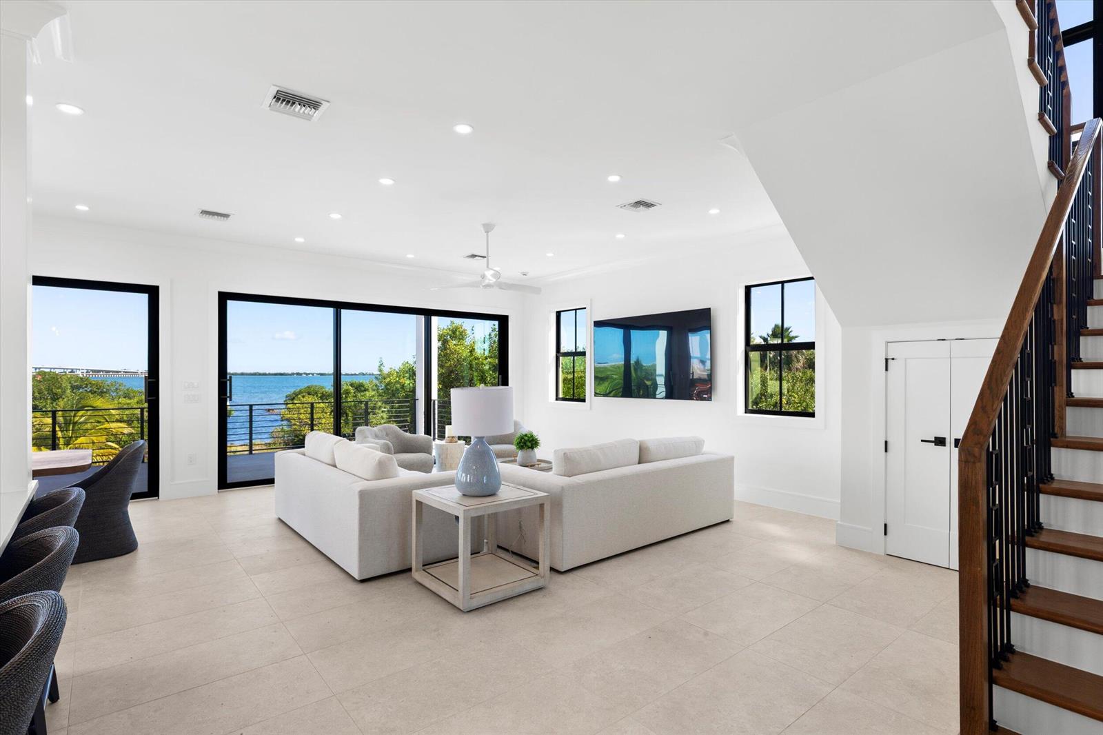 A staircase with wood treads and black metal railings sits beside a patterned powder room — 231 E Shore Drive Unit 6, Key West FL 33040, KEY WEST, FL