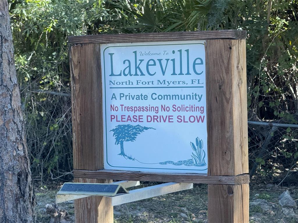 A wooden sign welcomes visitors to the private community of Lakeville in North Fort Myers — 2278 CHURCHILL LANE, NORTH FORT MYERS, FL