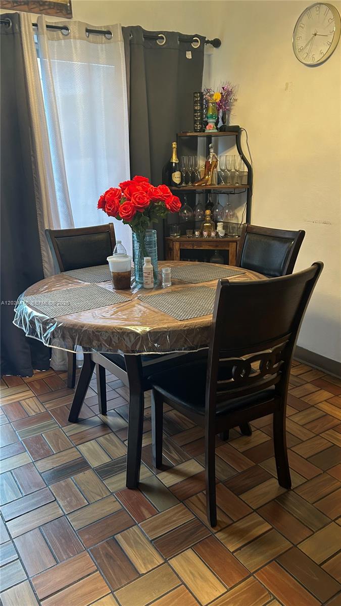 A dining area features a round wooden table with four chairs and a corner shelf — 11750 SW 186th St, Miami FL 33177, MIAMI, FL