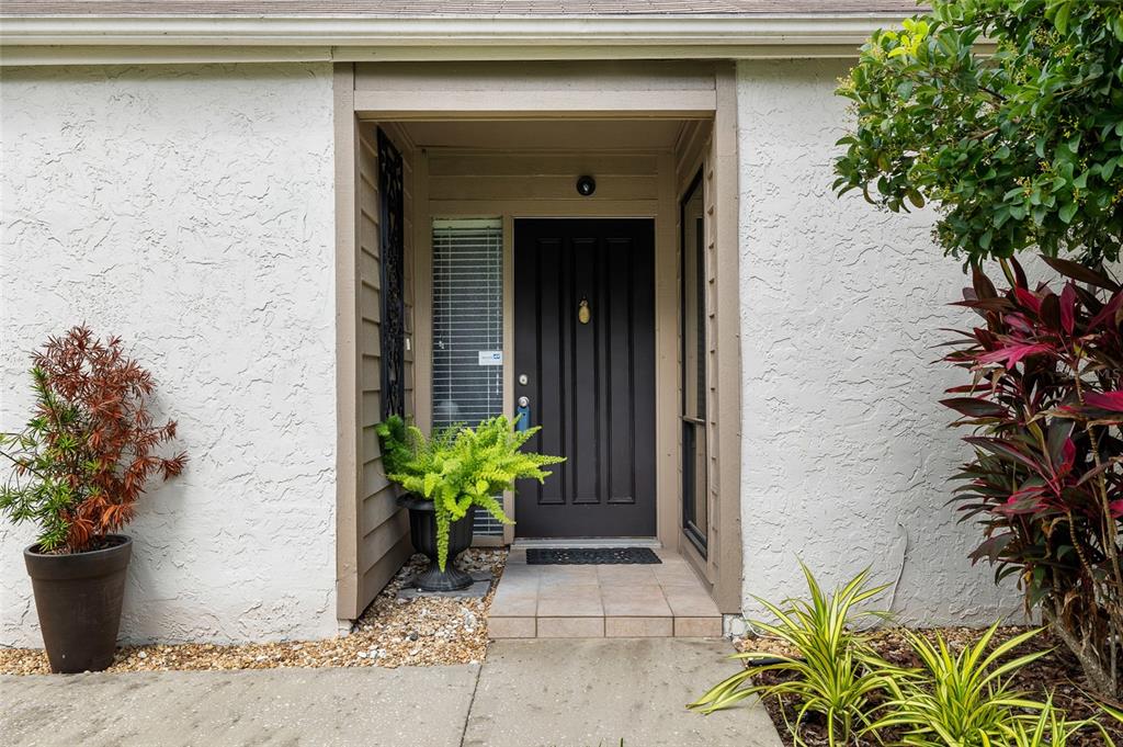 A living room features hardwood floors, a fireplace with a mounted television, and an entryway — 11520 GALLERIA DRIVE, TAMPA, FL
