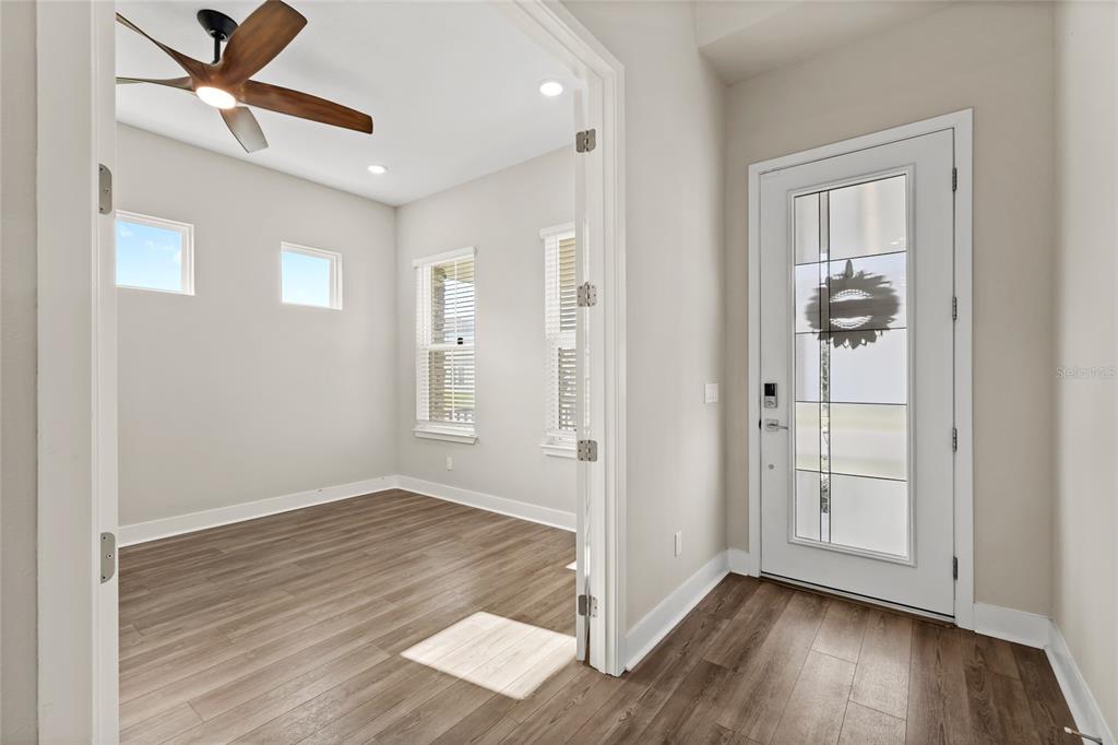 A room with wood-look flooring and a ceiling fan viewed through a doorway near an entryway — 16043 SILVER BROOK WAY, WINTER GARDEN, FL