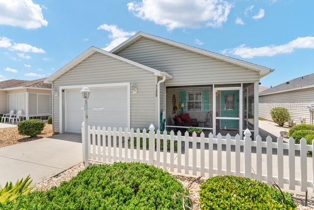 A light gray, single-story house features a white picket fence and a screened-in front porch — 1636 ABASCO COURT, THE VILLAGES, FL