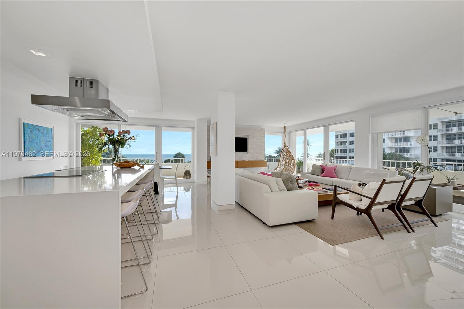 A bright, open-concept living area features a modern kitchen, white tile floors, and ocean views — 199 Ocean Lane Dr # 401, Key Biscayne FL 33149, KEY BISCAYNE, FL