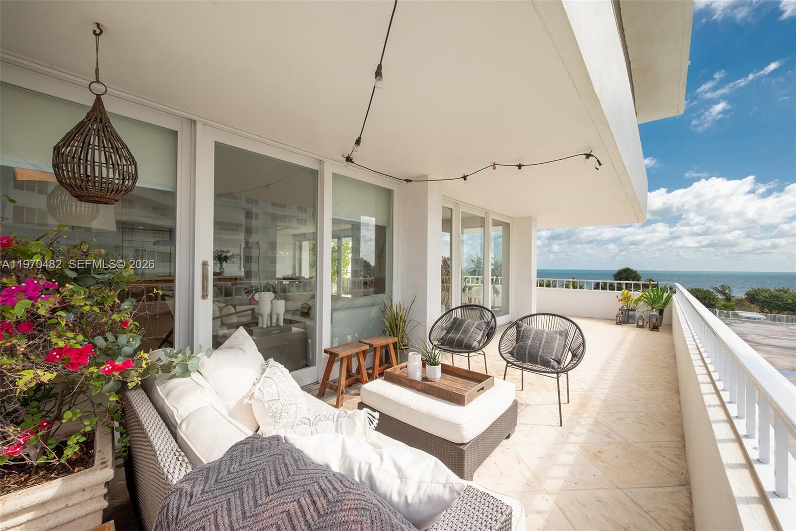 A balcony features a seating area with a sofa, two chairs, and ocean views — 199 Ocean Lane Dr # 401, Key Biscayne FL 33149, KEY BISCAYNE, FL