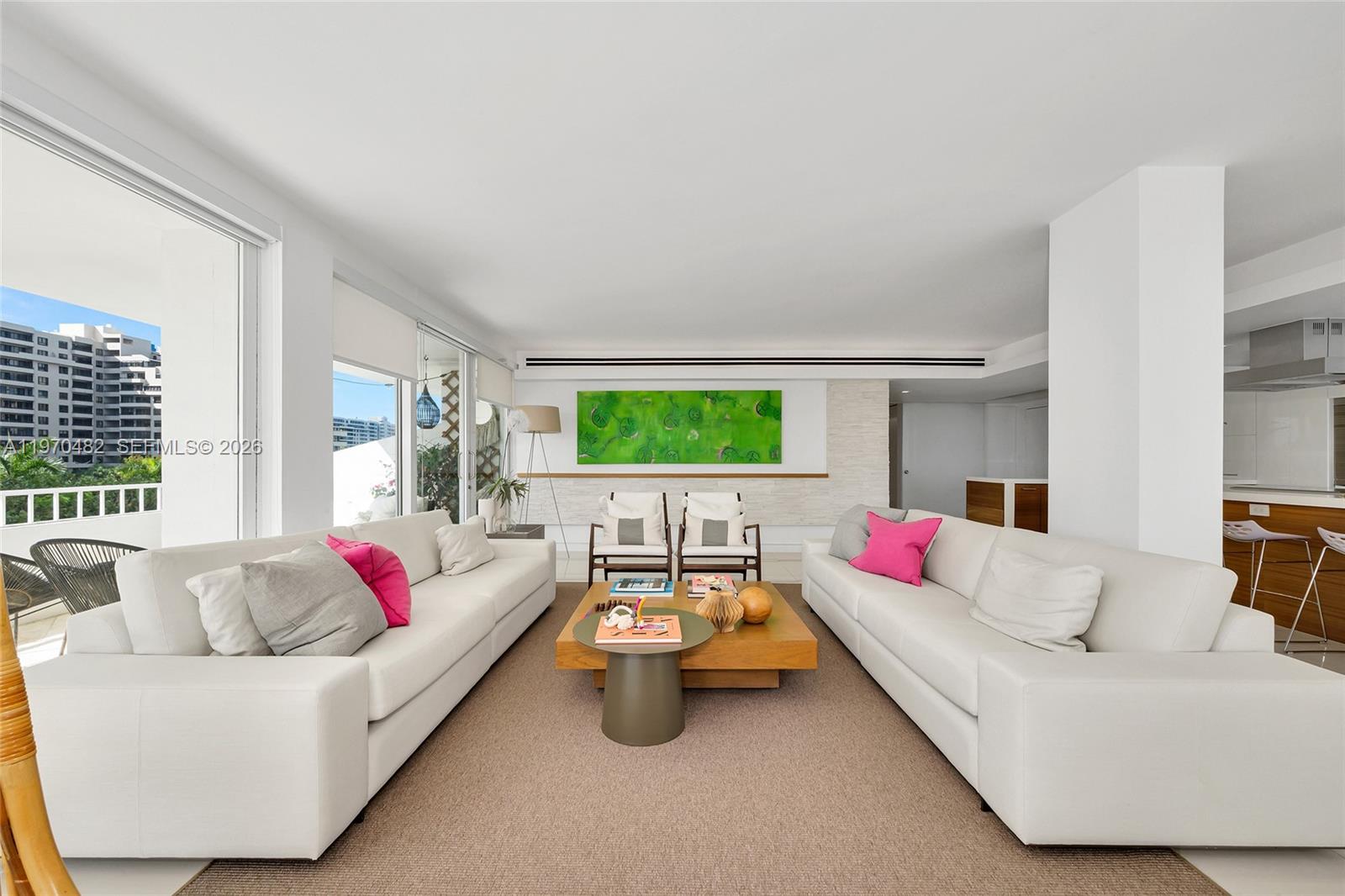 A bright living room features two white sofas, a wooden coffee table, and a balcony — 199 Ocean Lane Dr # 401, Key Biscayne FL 33149, KEY BISCAYNE, FL