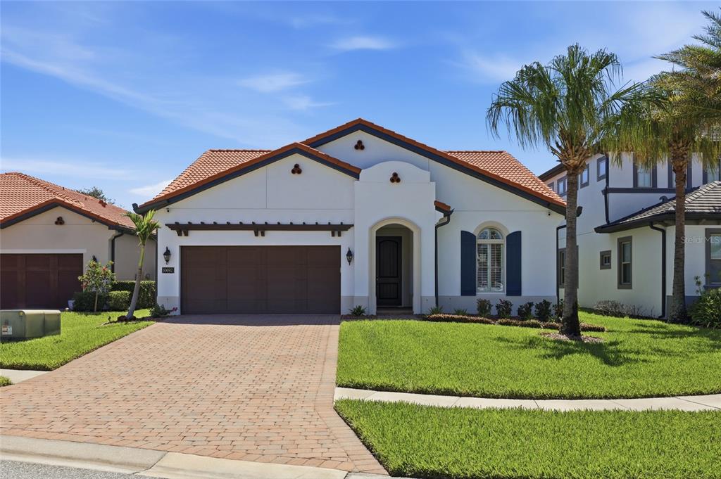 A single-story house with a white stucco exterior, tile roof, and a paved driveway — 10692 ROYAL CYPRESS WAY, ORLANDO, FL