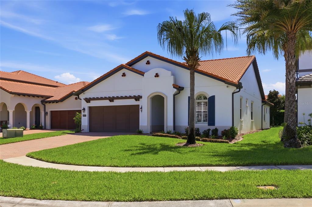 A single-story house with a tile roof, a two-car garage, and a front lawn — 10692 ROYAL CYPRESS WAY, ORLANDO, FL