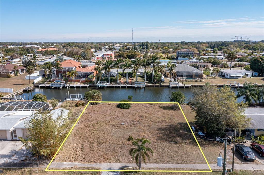 An aerial view shows a vacant, rectangular waterfront lot outlined in yellow — 109 BALDWIN COURT SE, PORT CHARLOTTE, FL